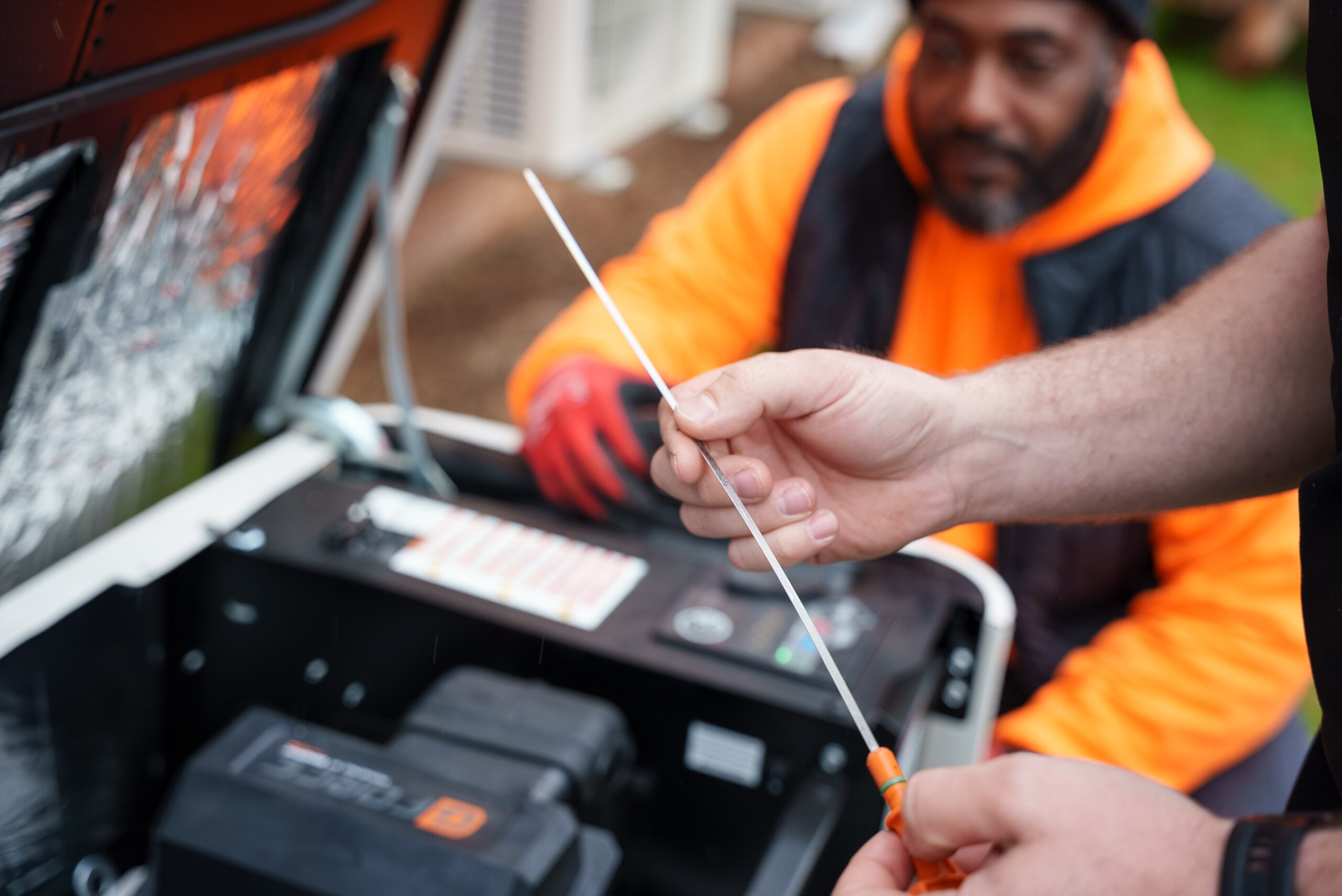 Technician checking oil on home generator in Greenville, SC - Carolina Heating Service Inc. Technician checking oil on home generator in Greenville, SC