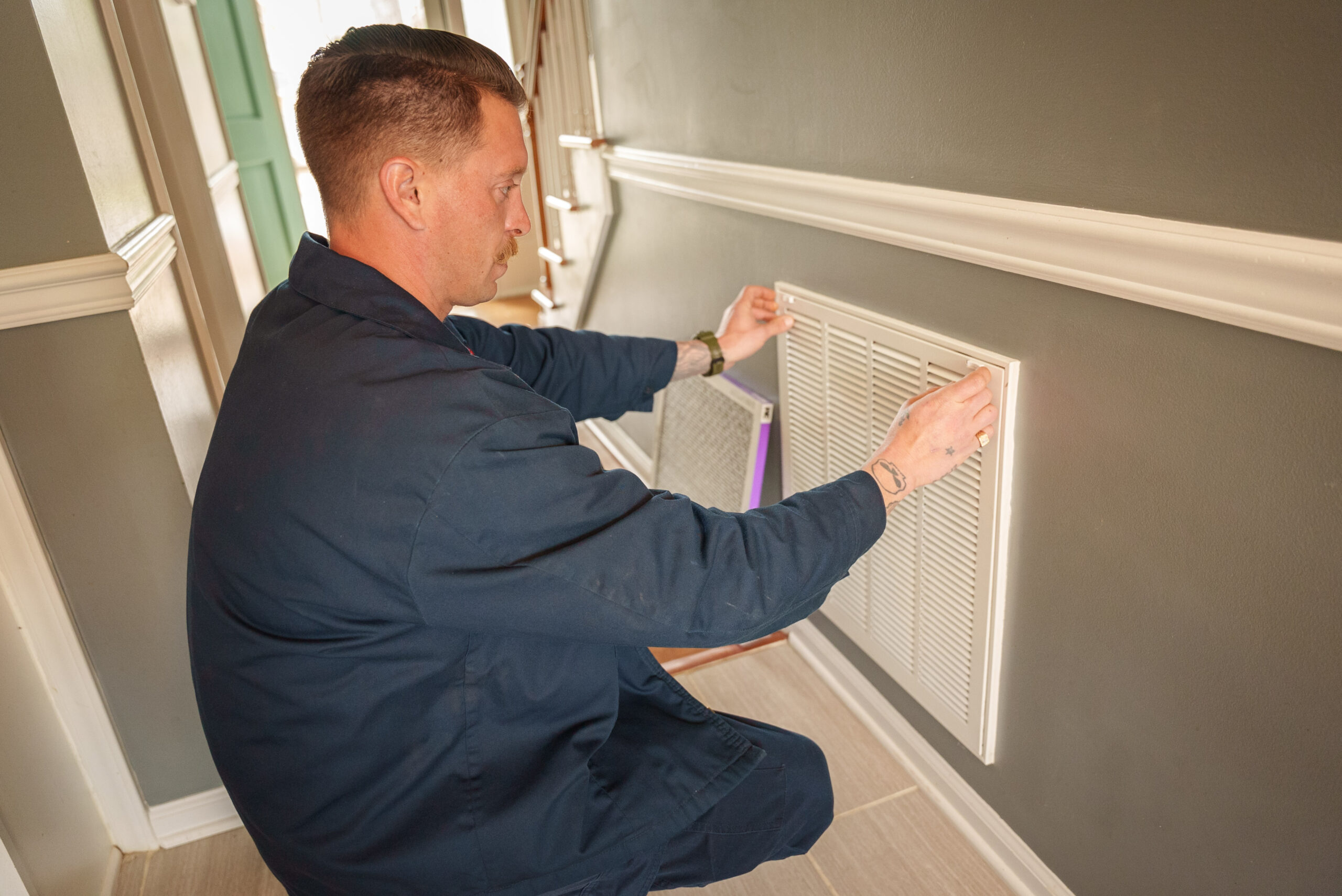 A Carolina Heating Service technician changing an air filter - Carolina Heating Service Inc. A Carolina Heating Service technician changing an air filter