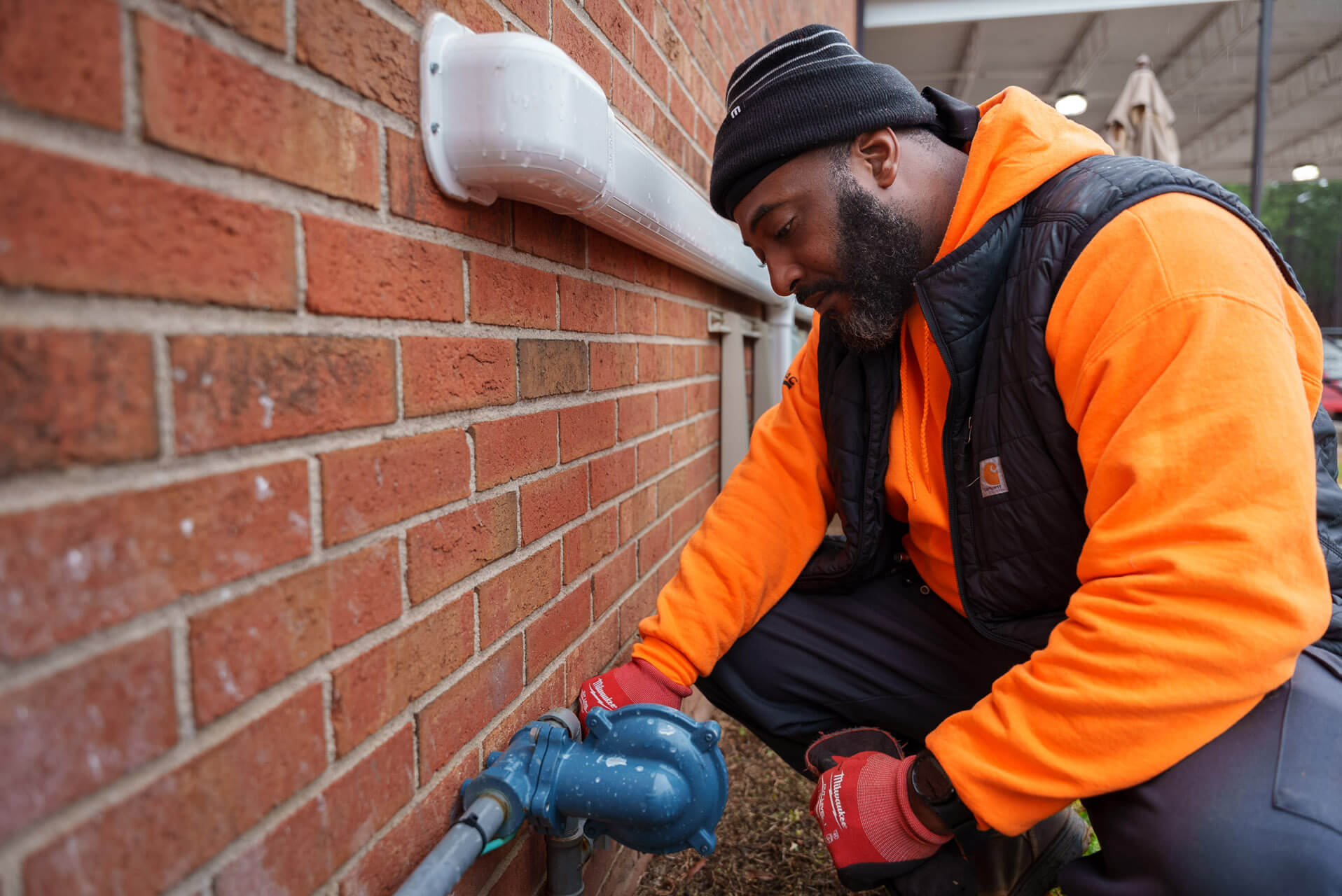A Carolina Heating Service technician inspecting a drain - Carolina Heating Service Inc. A Carolina Heating Service technician inspecting a drain