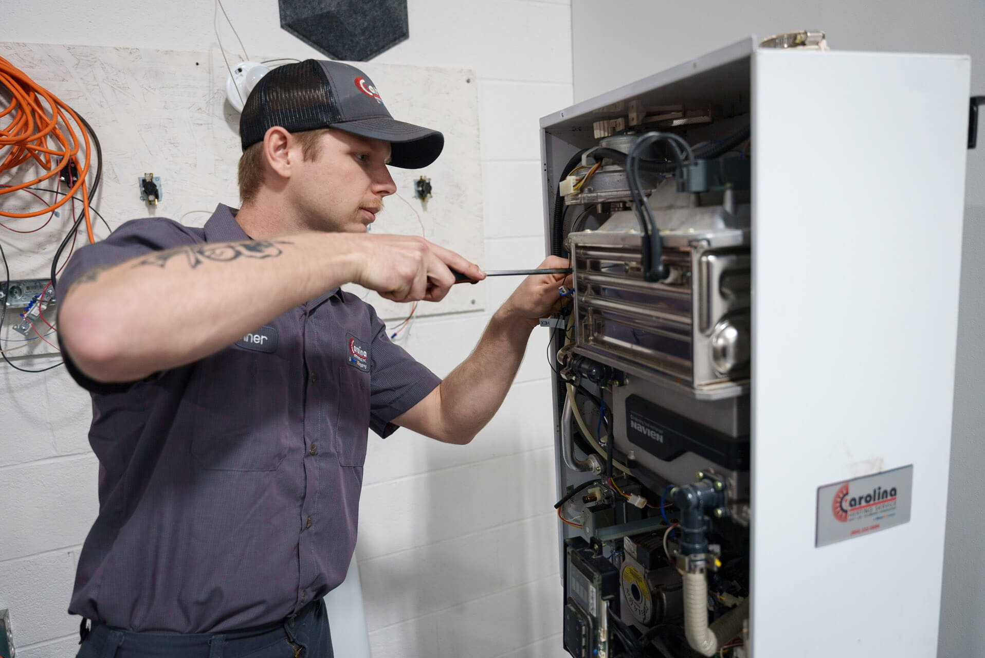 A Carolina Heating Service technician servicing a heating unit - Carolina Heating Service Inc. A Carolina Heating Service technician servicing a heating unit