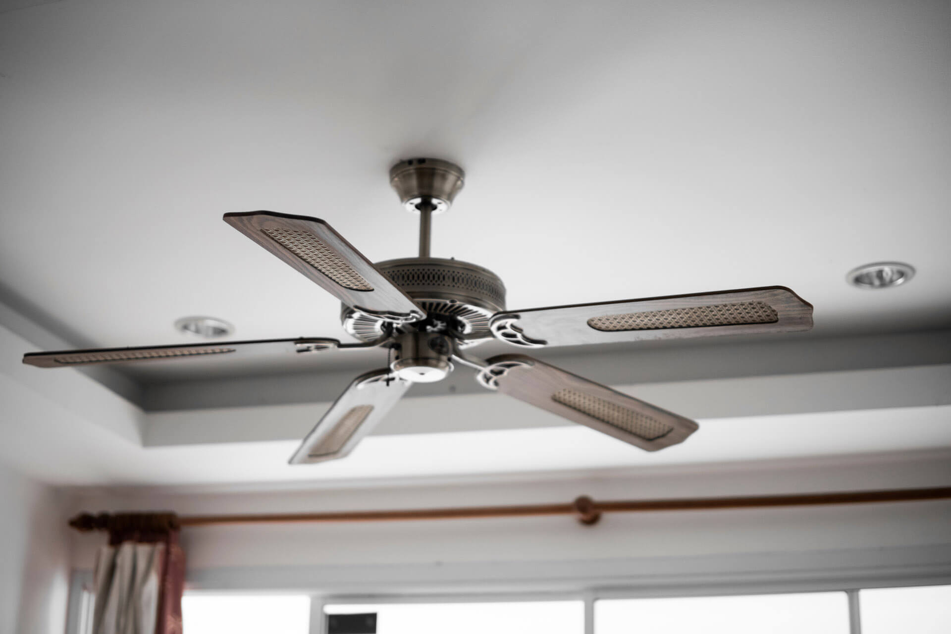 A ceiling fan installed on the ceiling of a home’s room - Carolina Heating Service Inc. A ceiling fan installed on the ceiling of a home’s room