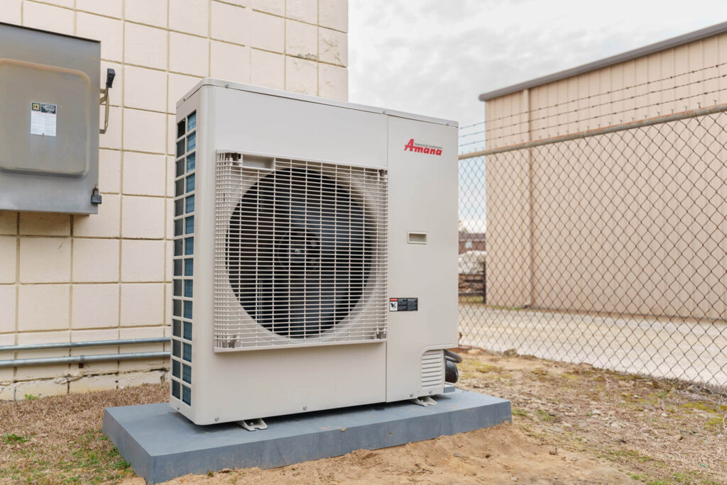 An Amana air conditioning unit installed outside of a building