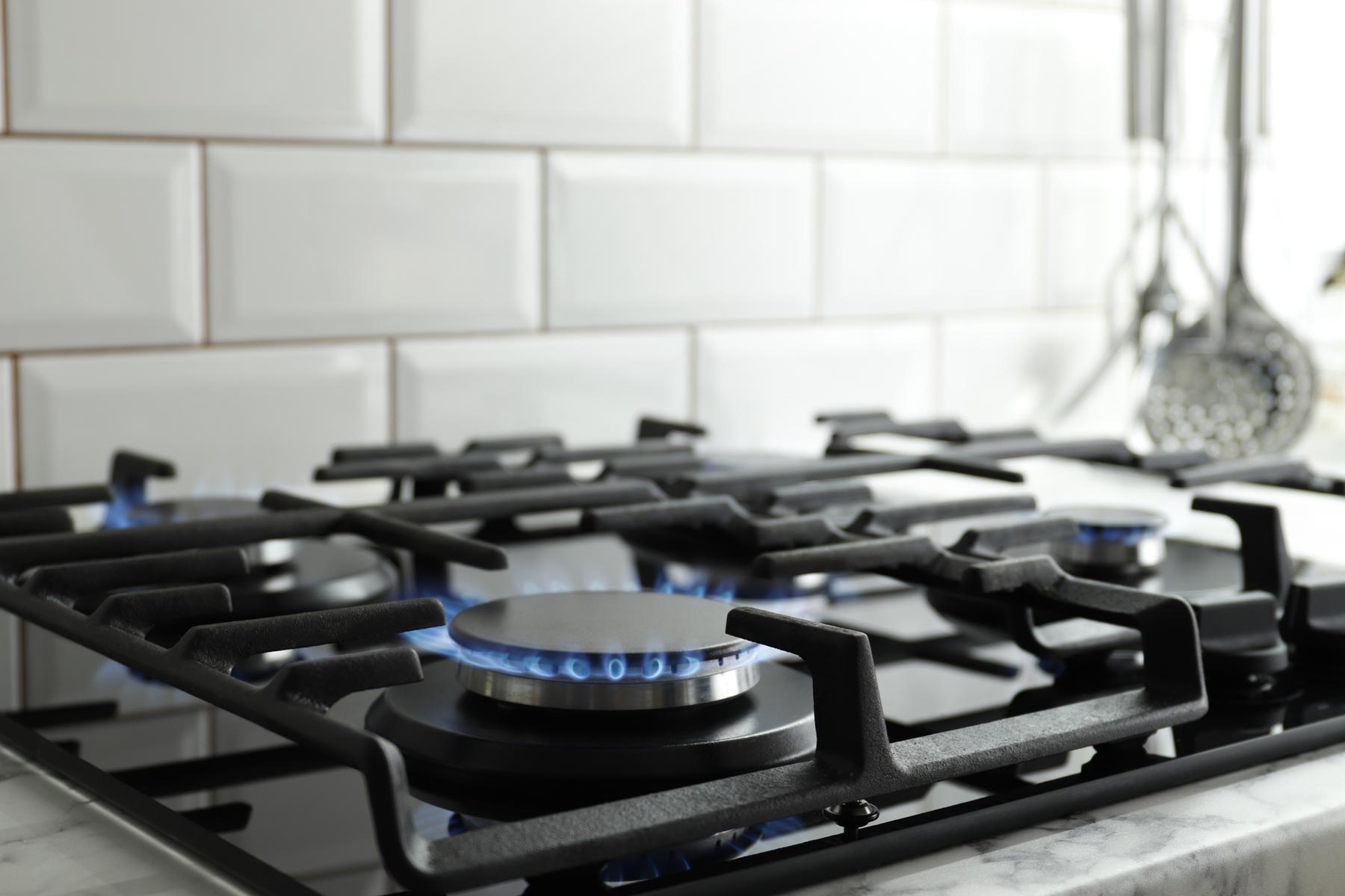 plumbing-services--gas-lines - Carolina Heating Service Inc. A gas stove with several of the burners lit, showing their blue flames