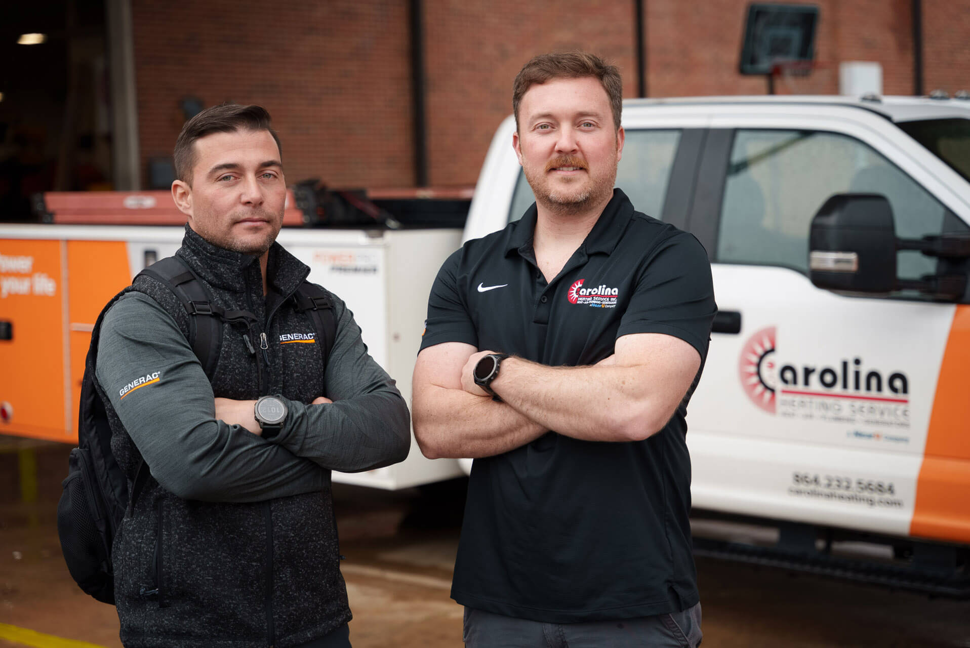 Two Carolina Heating Service technicians posing in front of a Carolina Heating Service truck - Carolina Heating Service Inc. Two Carolina Heating Service technicians posing in front of a Carolina Heating Service truck